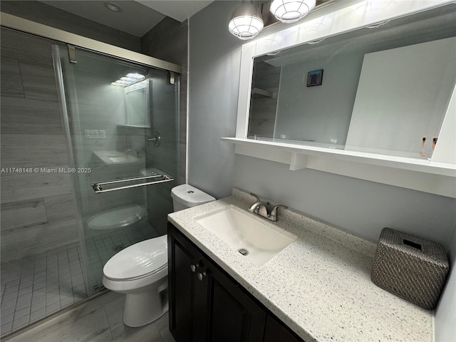 bathroom with vanity, toilet, and walk in shower