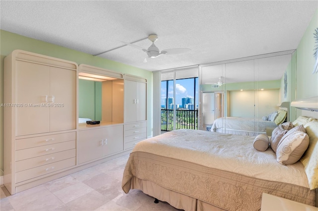 bedroom featuring a textured ceiling, ceiling fan, access to outside, and floor to ceiling windows