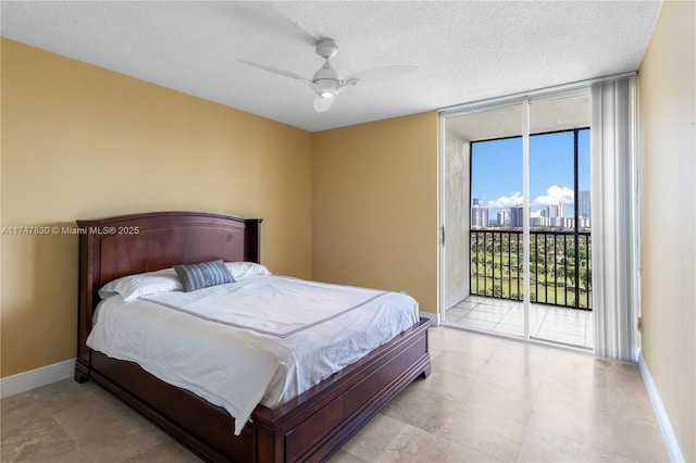 bedroom featuring ceiling fan, expansive windows, access to exterior, and a textured ceiling