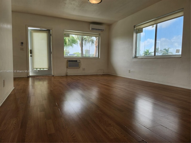 455 Golden Isles Dr Unit 309, Hallandale Beach, FL 33009 - unfurnished room featuring a wall mounted AC, dark hardwood / wood-style flooring, and plenty of natural light