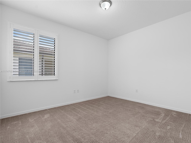 empty room with carpet floors and baseboards