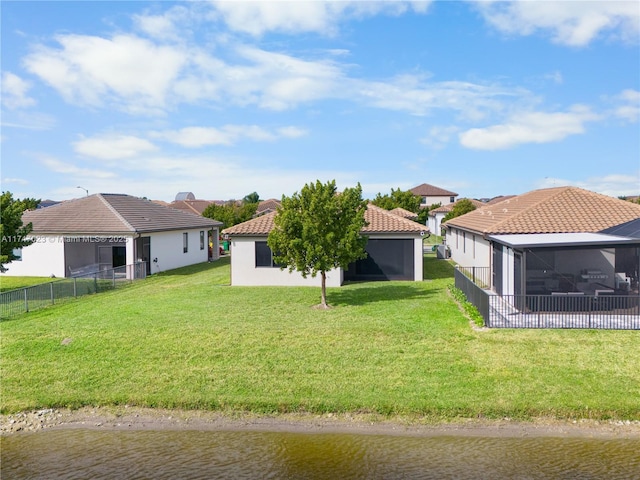 view of yard with a sunroom, a water view, and fence