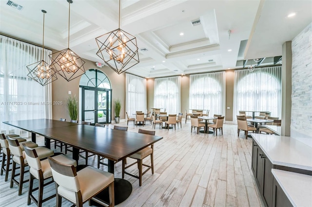 dining area with an inviting chandelier, visible vents, coffered ceiling, light wood-type flooring, and beamed ceiling