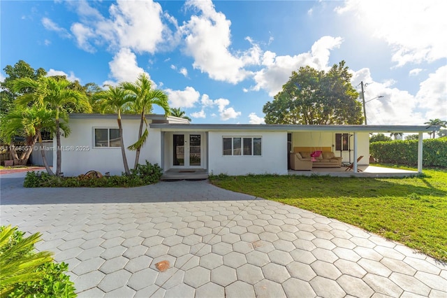 view of front of property featuring french doors and a front lawn