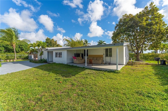 rear view of property featuring an outdoor living space, a yard, a patio area, and stucco siding