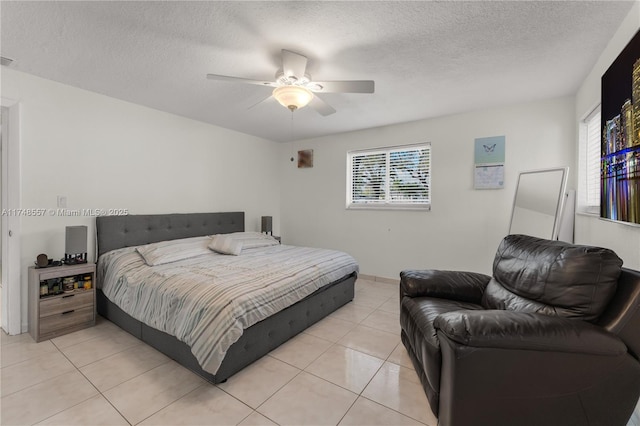 bedroom with light tile patterned floors, a ceiling fan, visible vents, and a textured ceiling