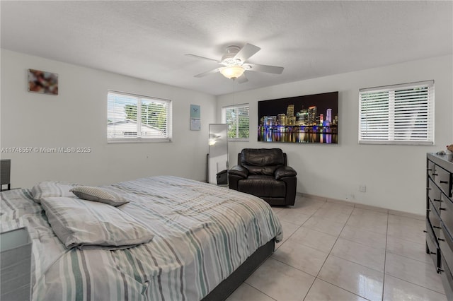 bedroom with light tile patterned floors, a textured ceiling, and a ceiling fan