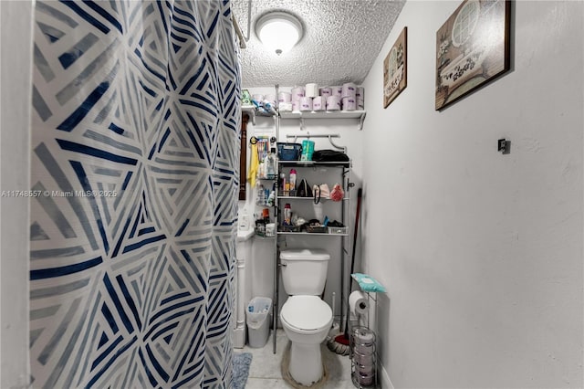 full bathroom with toilet and a textured ceiling