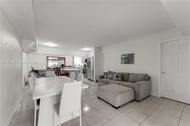 living room featuring light tile patterned floors and baseboards