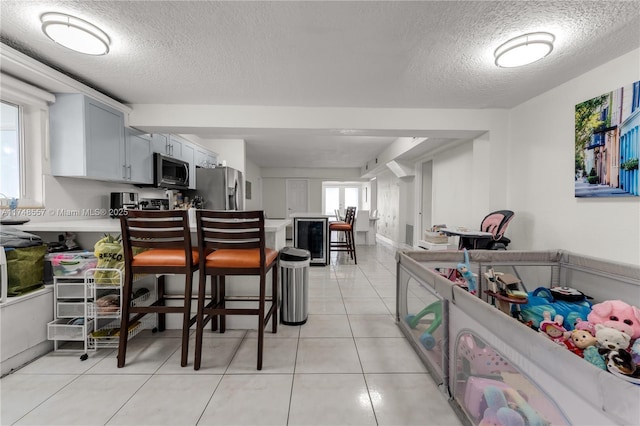 kitchen featuring light countertops, light tile patterned floors, appliances with stainless steel finishes, and a textured ceiling
