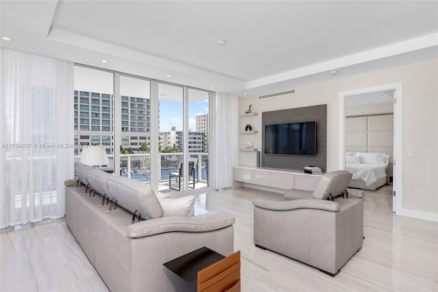 living room with a raised ceiling and expansive windows