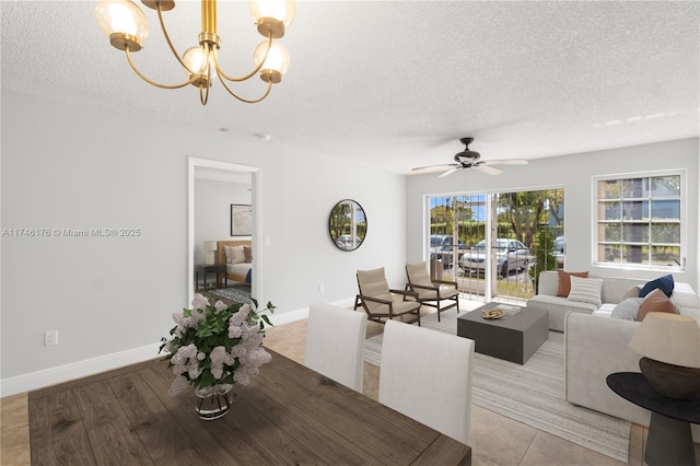 dining area featuring baseboards, a textured ceiling, and ceiling fan with notable chandelier