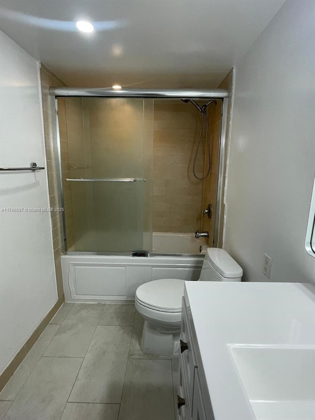 full bathroom featuring vanity, bath / shower combo with glass door, and toilet