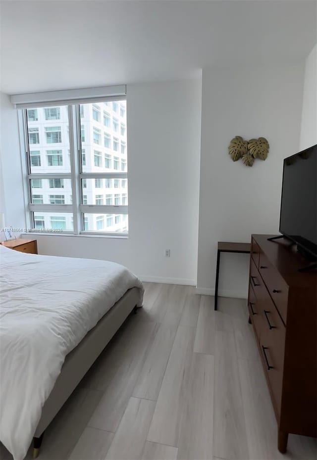 bedroom featuring light wood-style flooring and baseboards