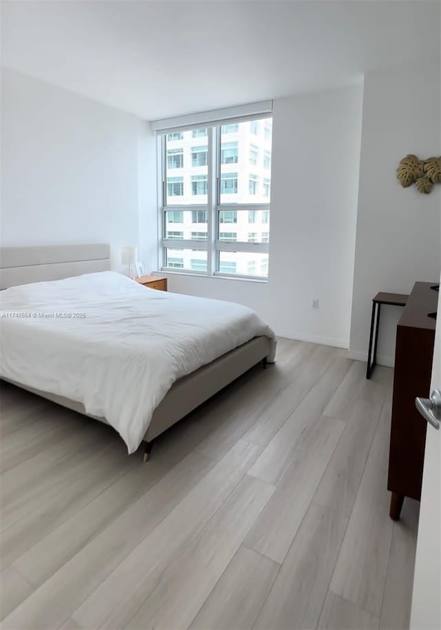 bedroom featuring light wood-type flooring and baseboards