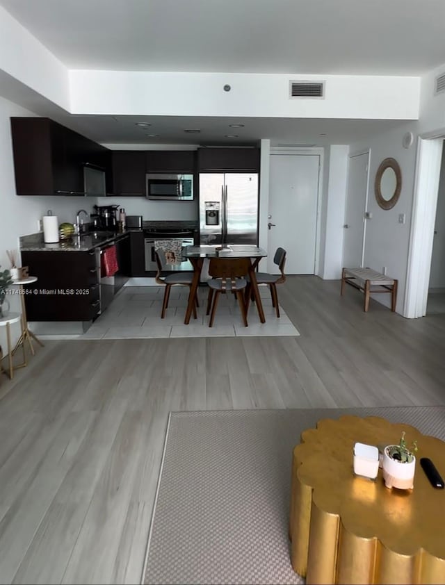 dining area featuring light wood-type flooring and visible vents