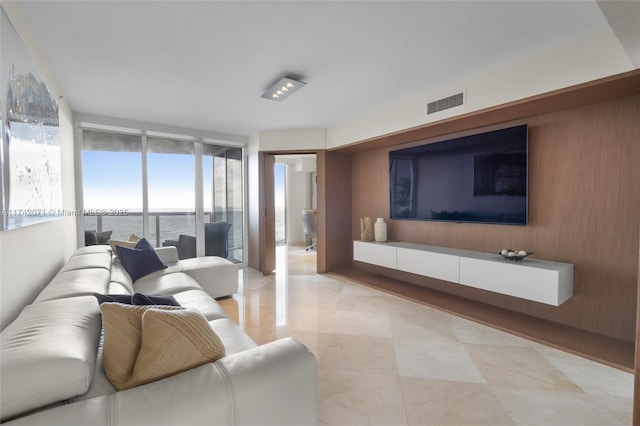 living area featuring floor to ceiling windows and visible vents