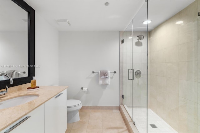 full bathroom with toilet, vanity, a shower stall, baseboards, and tile patterned floors