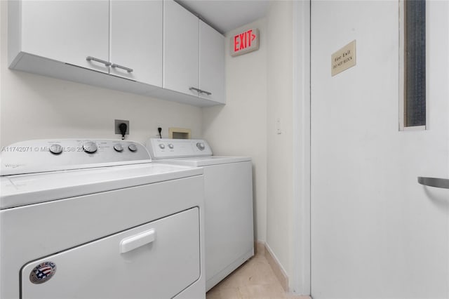 laundry area with washing machine and clothes dryer, cabinet space, and baseboards