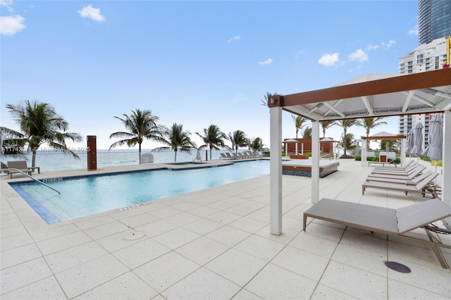 pool with a patio and a water view