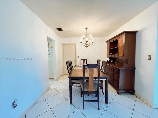 dining area with a notable chandelier and light tile patterned floors