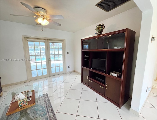 tiled living room featuring ceiling fan and french doors