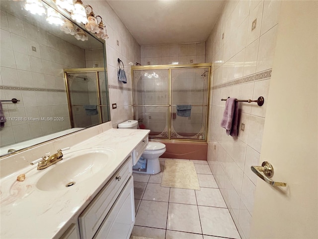 full bathroom featuring bath / shower combo with glass door, tile patterned flooring, tile walls, and vanity