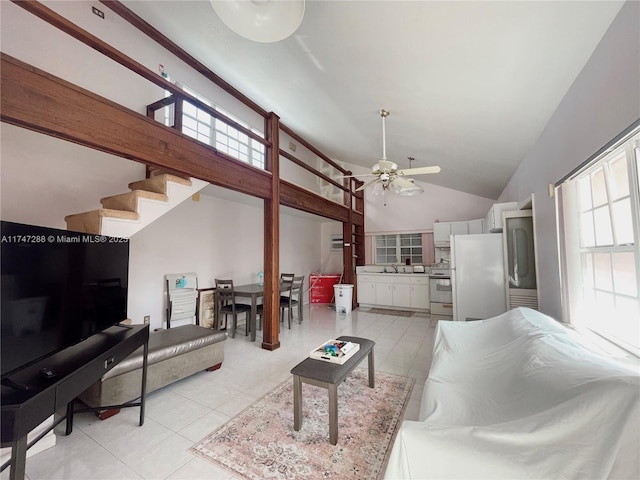 tiled living room with ceiling fan, high vaulted ceiling, and sink