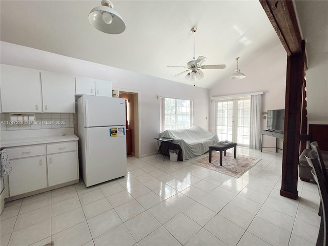 kitchen with ceiling fan, high vaulted ceiling, white refrigerator, light tile patterned floors, and white cabinetry