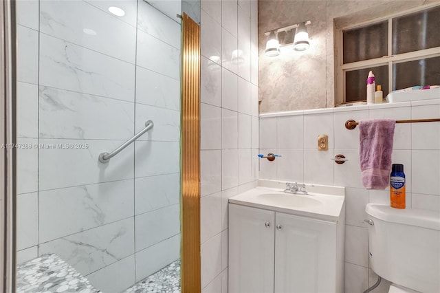 bathroom featuring tile walls, vanity, and toilet