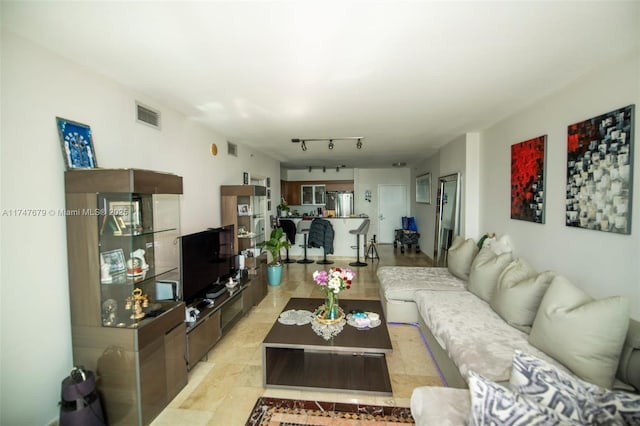 living area with rail lighting and visible vents