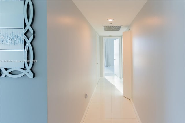 hall with baseboards, light tile patterned flooring, and visible vents