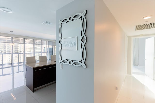interior space featuring light tile patterned floors, baseboards, and visible vents