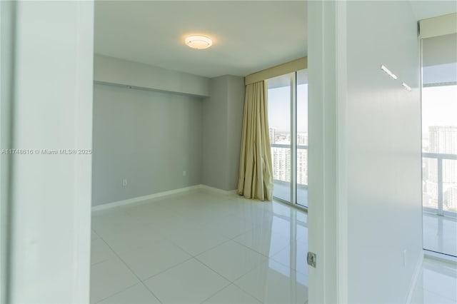 unfurnished room featuring light tile patterned floors and baseboards