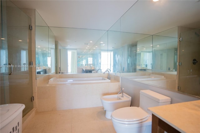 bathroom featuring vanity, toilet, a bidet, a garden tub, and a stall shower