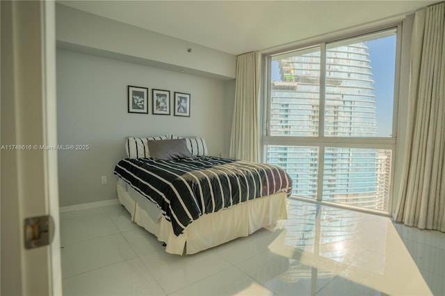 bedroom featuring tile patterned floors, multiple windows, and baseboards