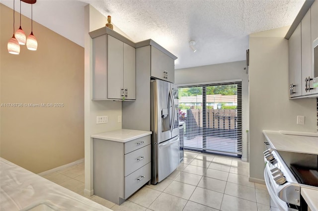 kitchen with appliances with stainless steel finishes, a textured ceiling, decorative light fixtures, gray cabinets, and light tile patterned floors