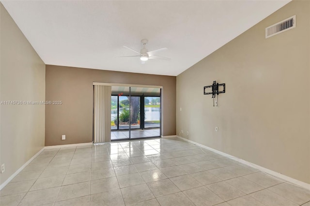 tiled empty room featuring lofted ceiling and ceiling fan