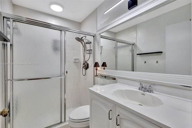 bathroom featuring toilet, vanity, and an enclosed shower