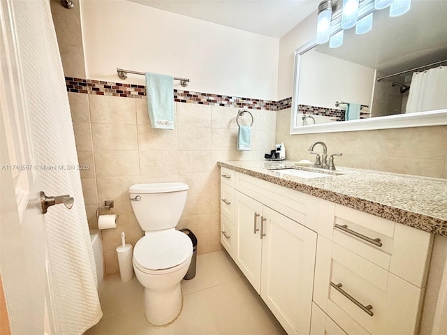 bathroom with tile walls, vanity, tile patterned flooring, and toilet