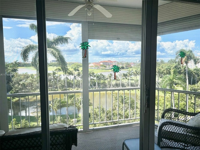 interior space with a water view, ceiling fan, and a healthy amount of sunlight