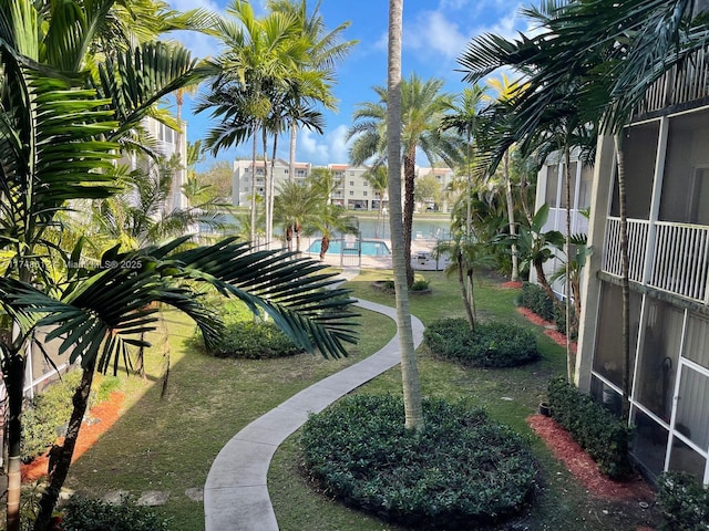 view of property's community with a pool and a lawn