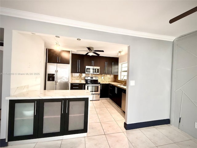 kitchen featuring appliances with stainless steel finishes, light tile patterned floors, crown molding, kitchen peninsula, and tasteful backsplash