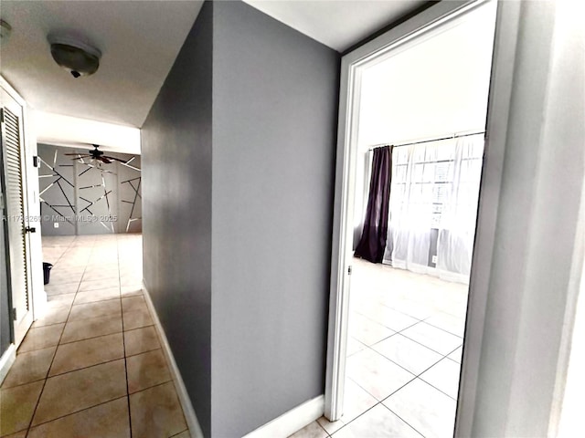 hall with baseboards and light tile patterned floors