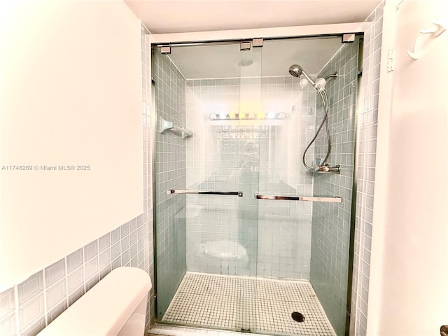 bathroom with a shower stall and toilet