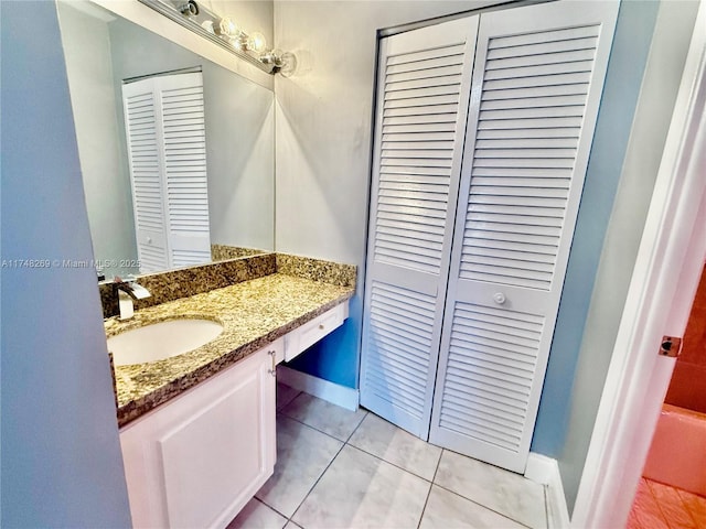 bathroom with baseboards, a closet, vanity, and tile patterned floors