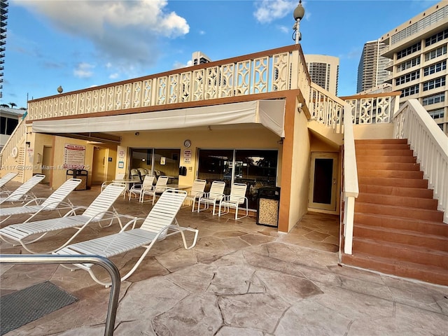 back of property with a patio area, a view of city, and stairway