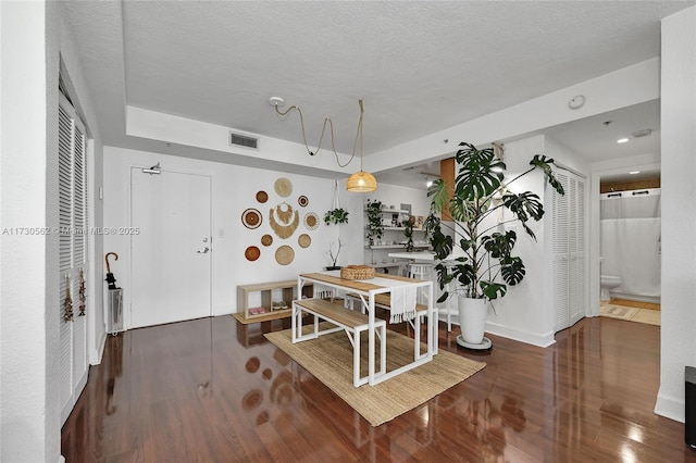 dining area featuring a textured ceiling and dark wood-type flooring