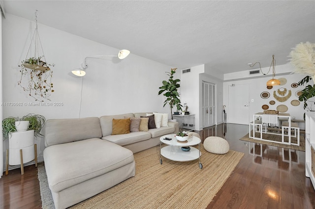 living room featuring a textured ceiling and dark hardwood / wood-style flooring