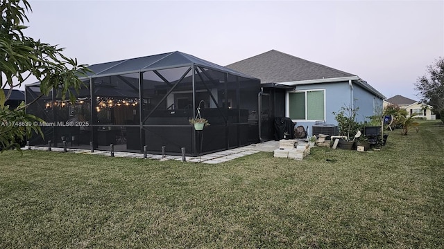 back of house with glass enclosure, central AC unit, and a lawn